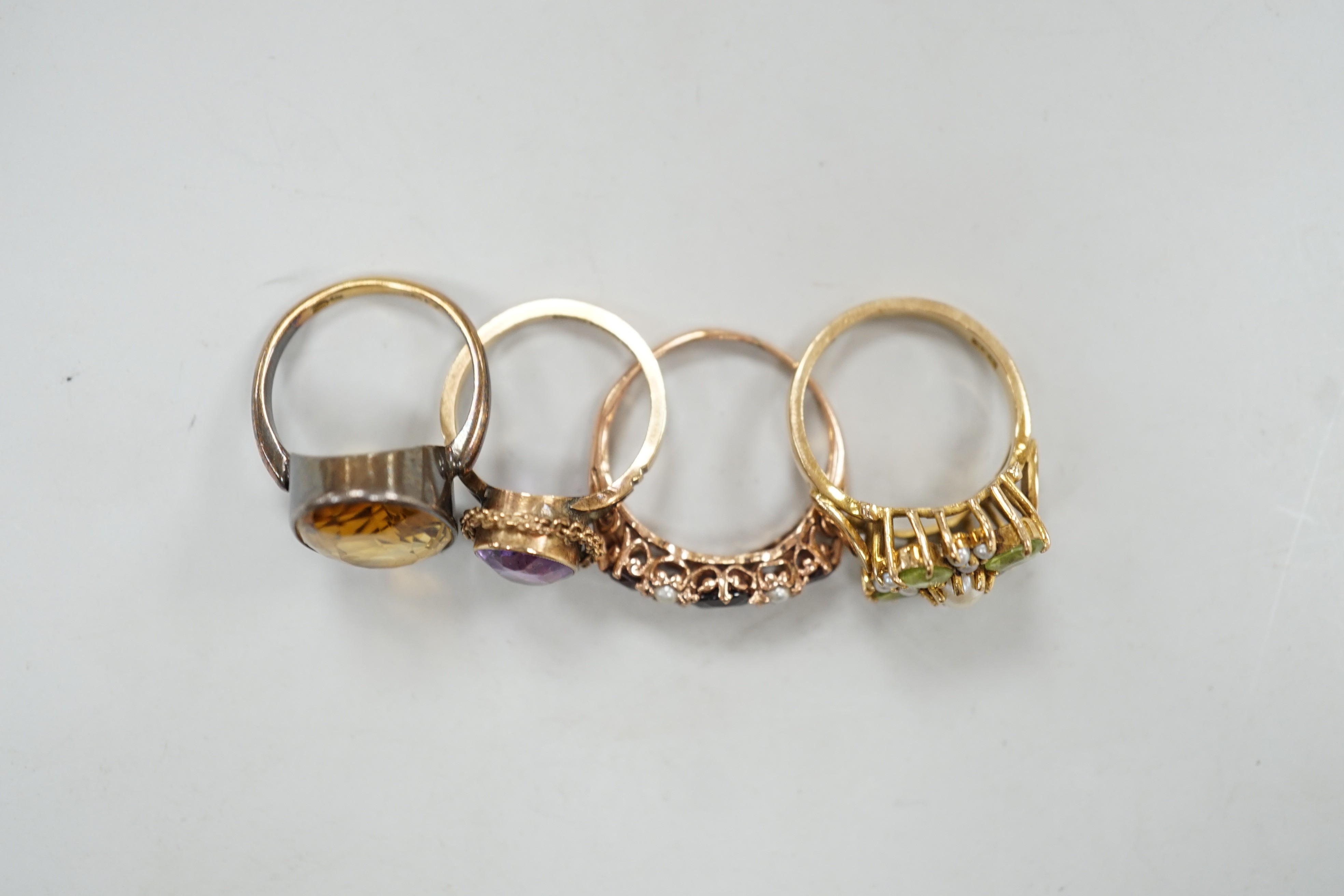 An 18ct gold and citrine set oval ring, size M/N, gross weight 5.8 grams and three assorted 9ct and gem set dress rings including peridot and seed pearl, gross weight 10.3 grams.